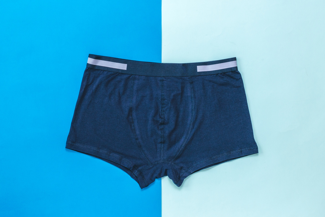 Dark blue men's underwear with light stripes on a two-color background.